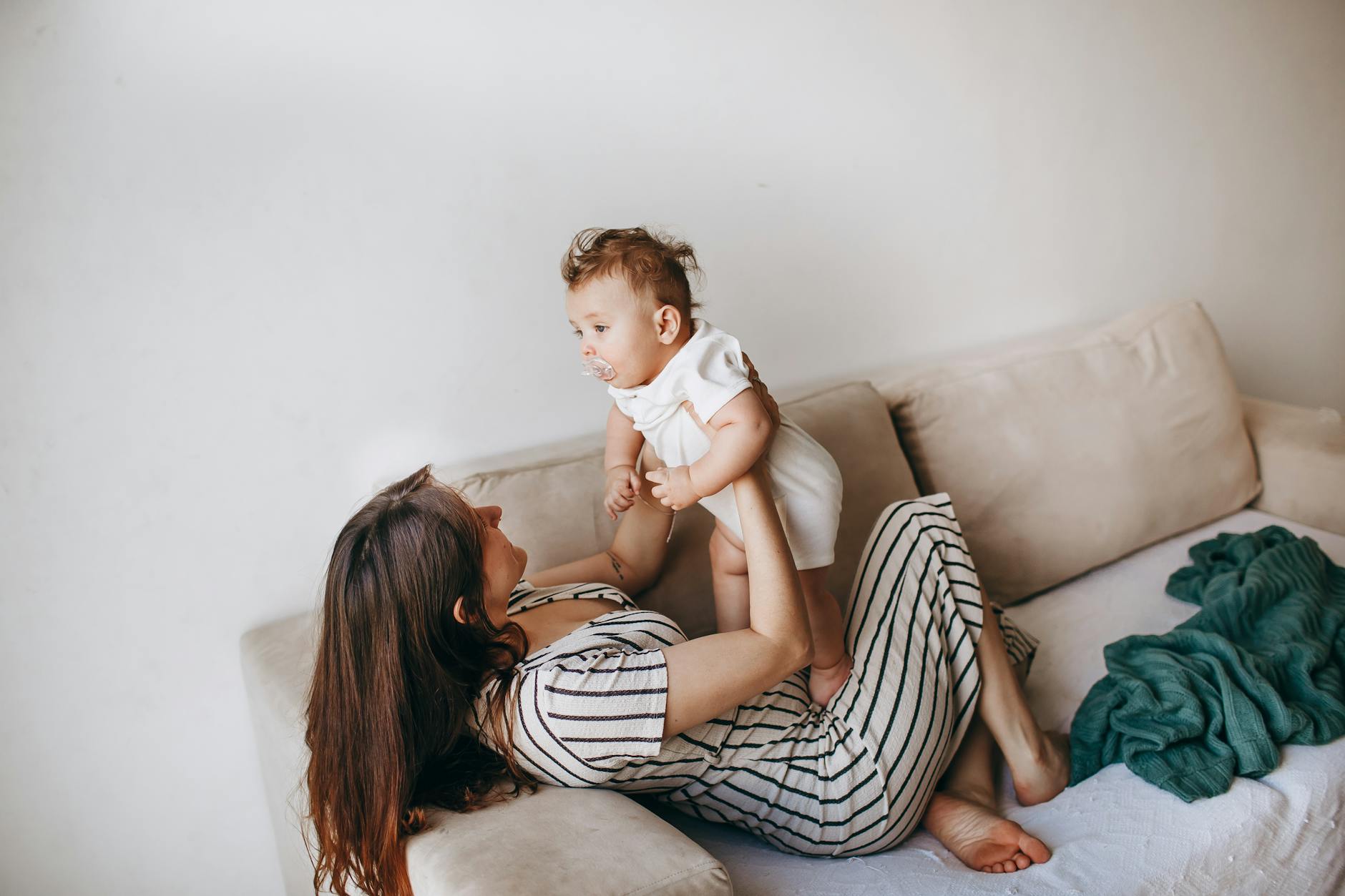 woman holding baby with pacifier