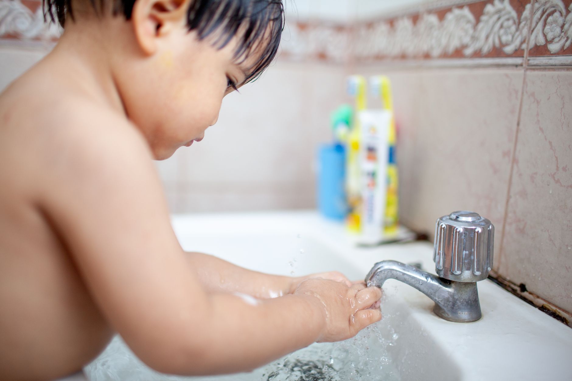 photograph of a child washing his hands